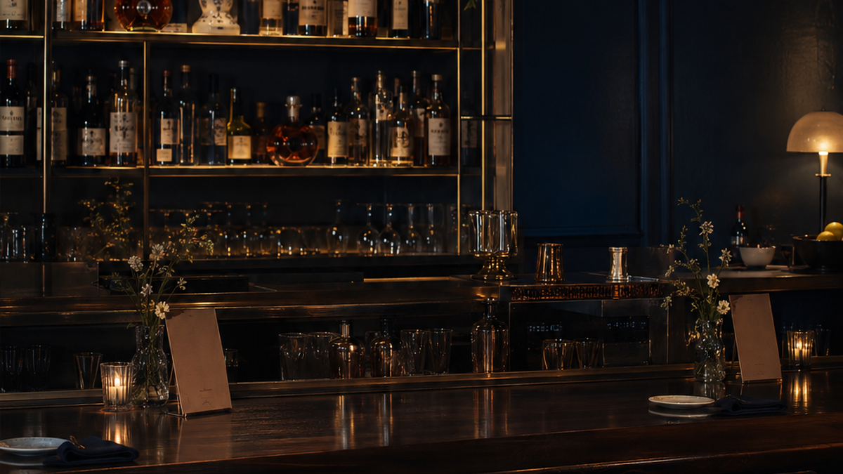 A quiet cocktail bar backbar and dining counter after service